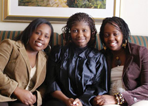 Three Female African students sitting on a couch together.