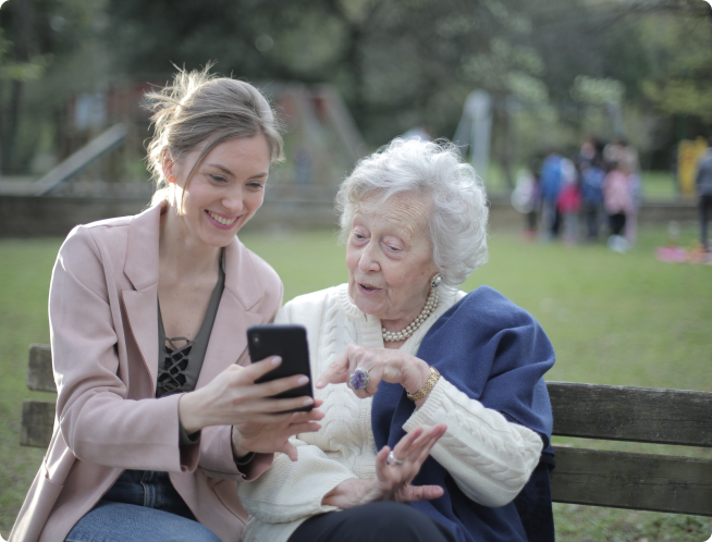 A younger woman showing something on her phone with an older woman.