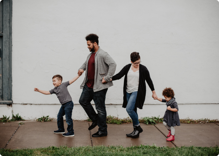 A family holding hands, making a chain walking one behind the other.