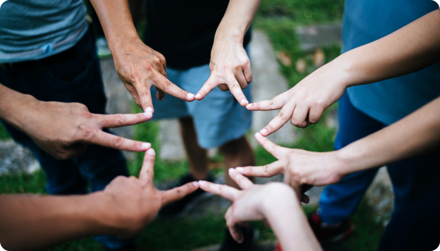 Children putting their fingers next to each other to create a star shape